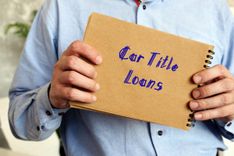 man holding notepad with writing that reads car title loans