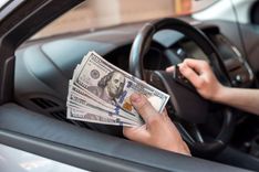 person in their car counting title installment loan cash from being approved at Nevada Title and Payday Loans, Inc
