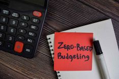 desktop with calculator and notepad for working on zero based budgeting