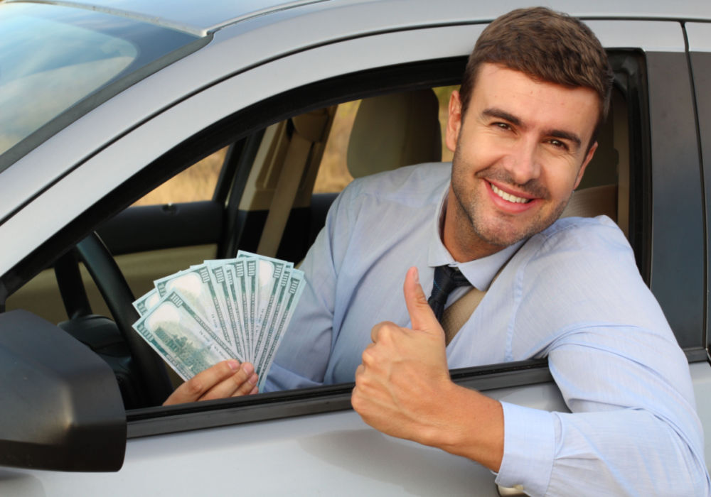 man with his car and title pawn cash