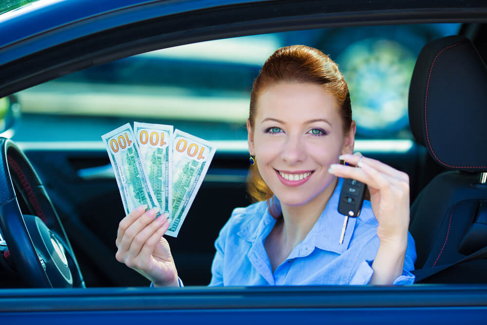 woman in car with title loan money