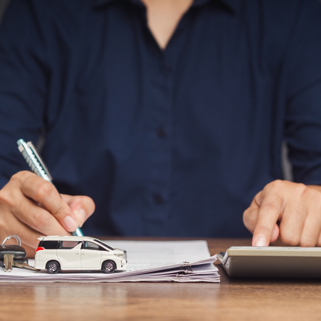 Representative stamping approved title loan paperwork at their desk with text What Do You Need To Get A Title Loan Online?