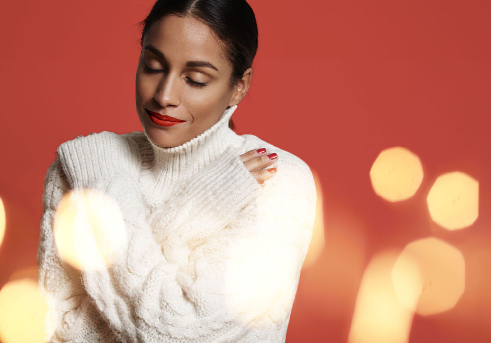 A woman hugs herself after following self-care tips for the holidays.