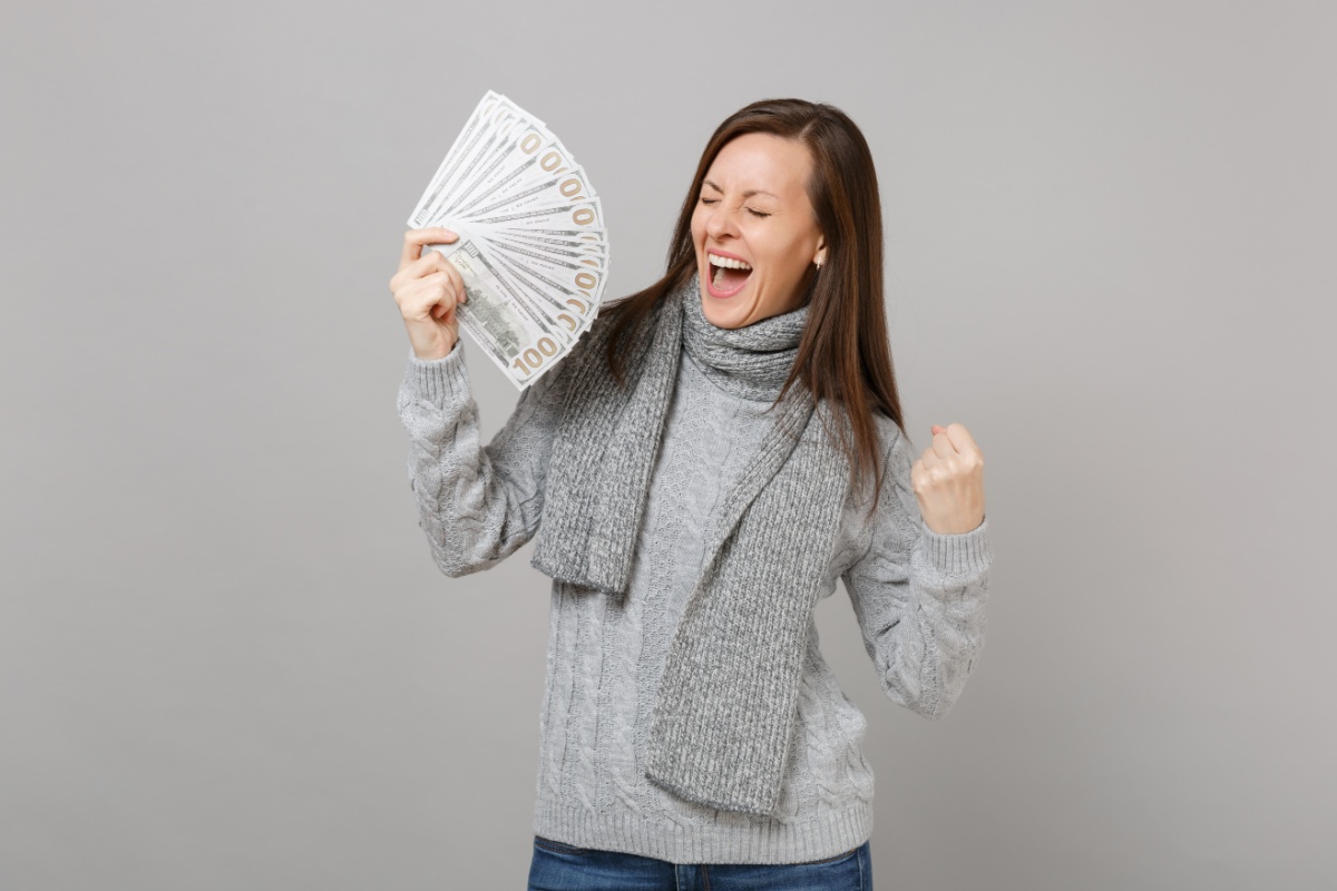 woman dressed for winter holds title loan cash for utility bills