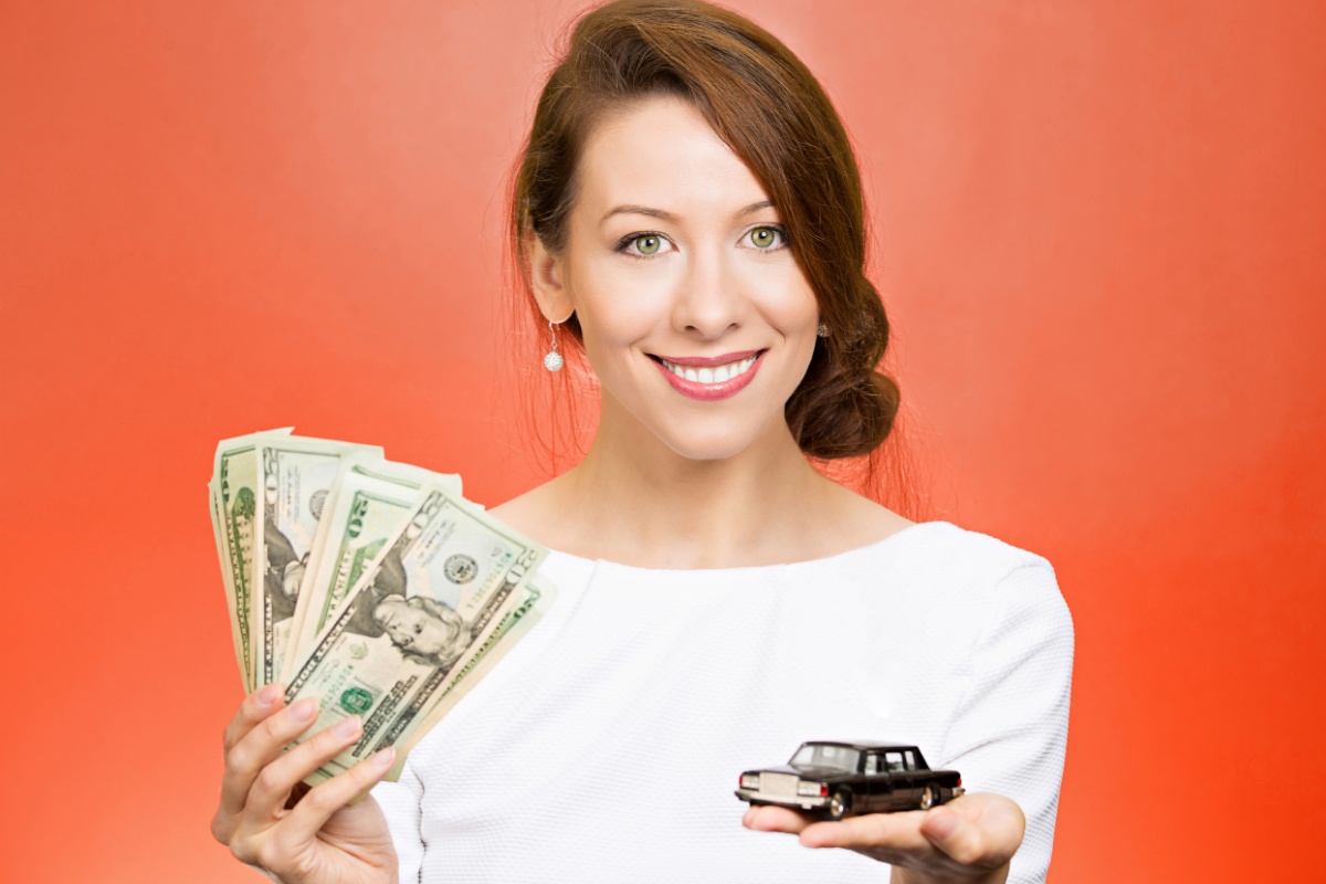 woman holding car and title loan cash
