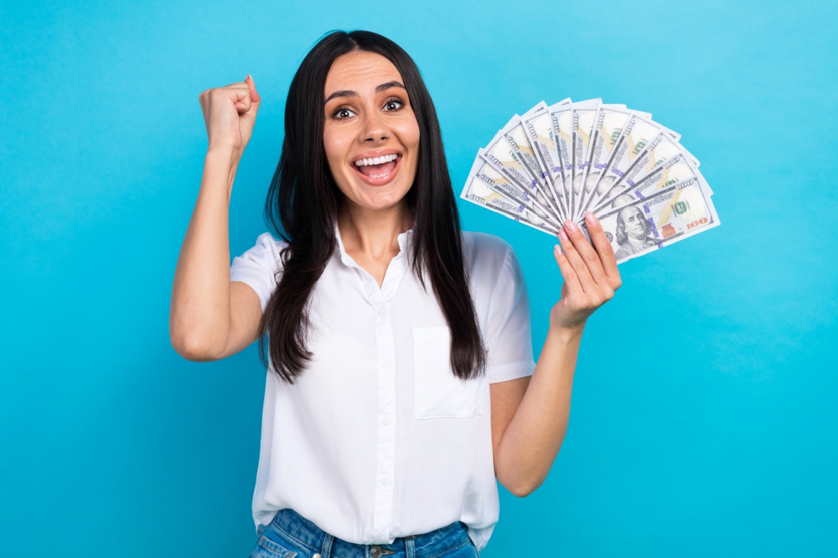 woman happy and holding cash from bad credit title loan