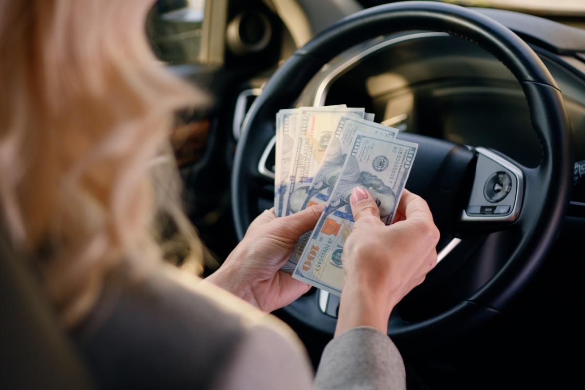 woman holding title loan cash in her car