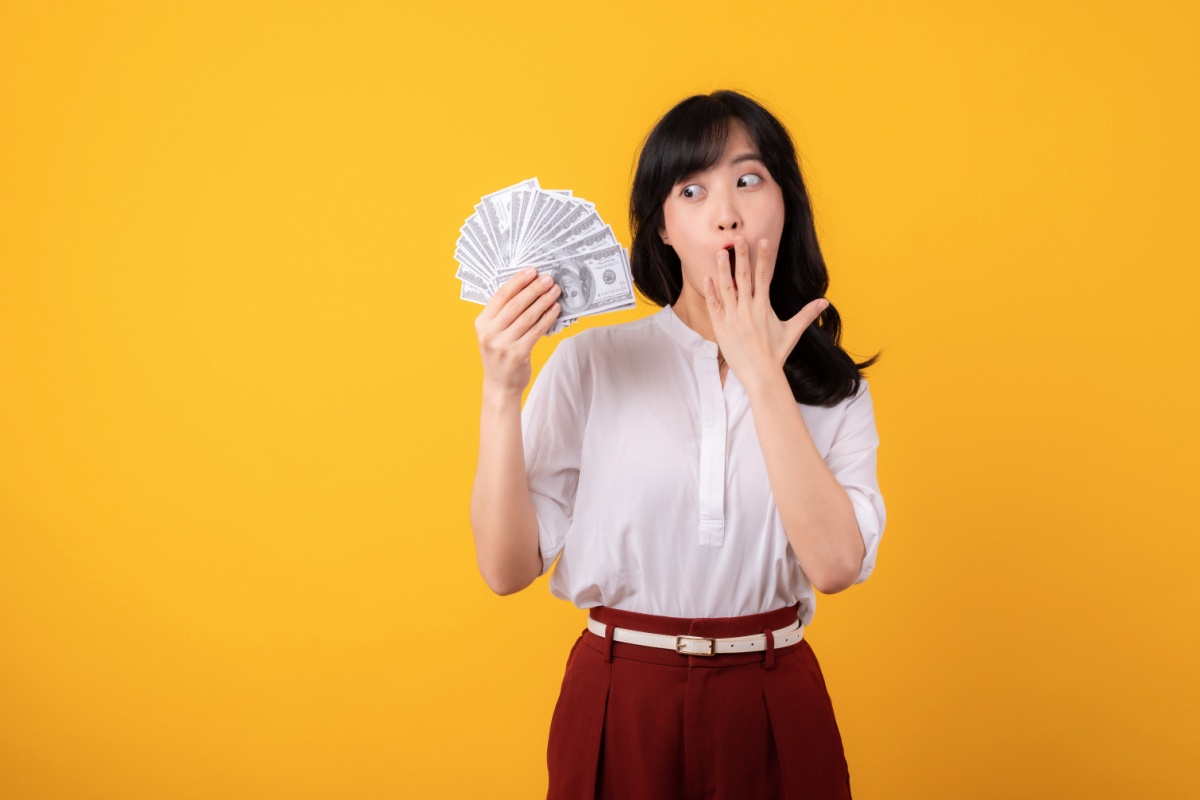 woman holds cash from registration loan