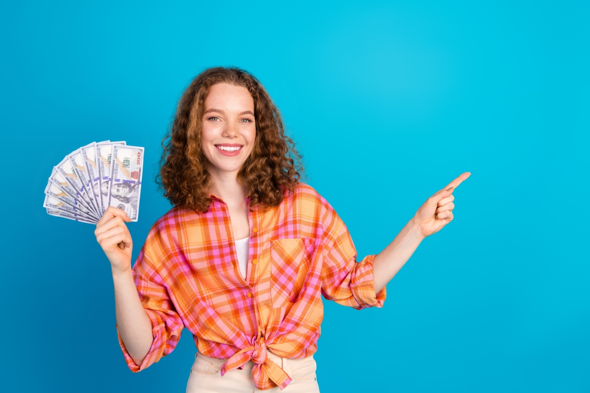woman holds cash from repeat customer title loan