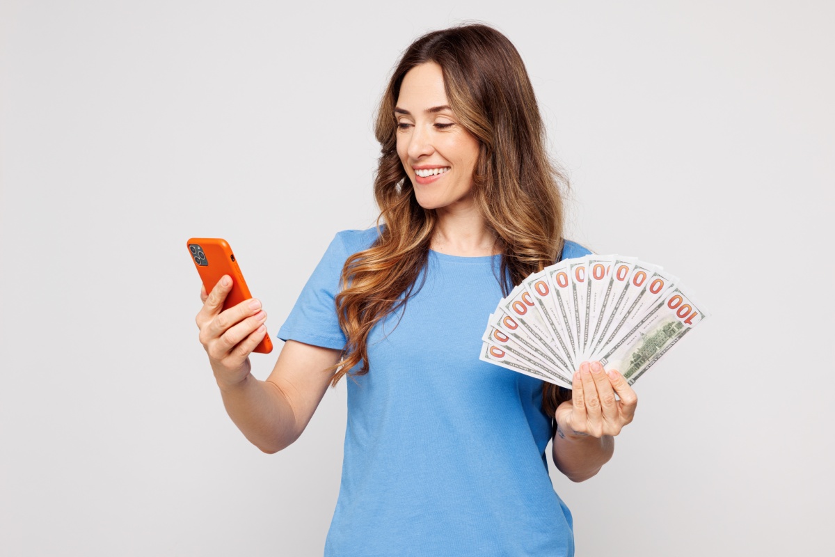 woman holds phone from emergency cash from online title loan in Houston