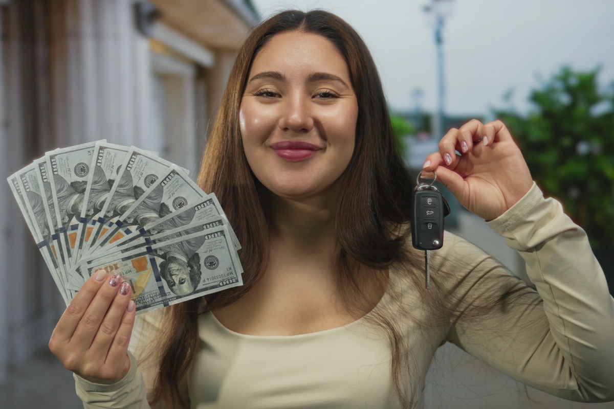 woman holds title loan cash and car key