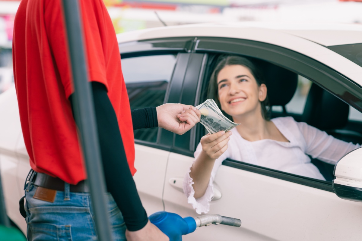 woman pays for gas costs in 2026