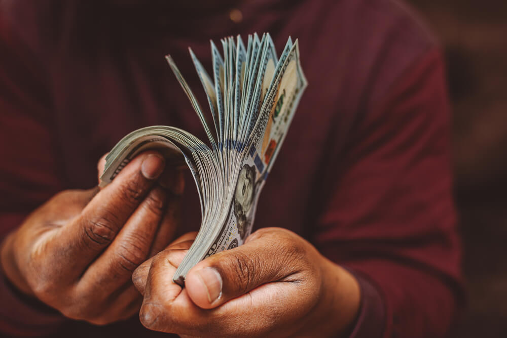 man flipping through car title loan cash