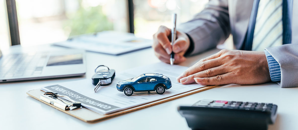 man signing auto registration loan contract