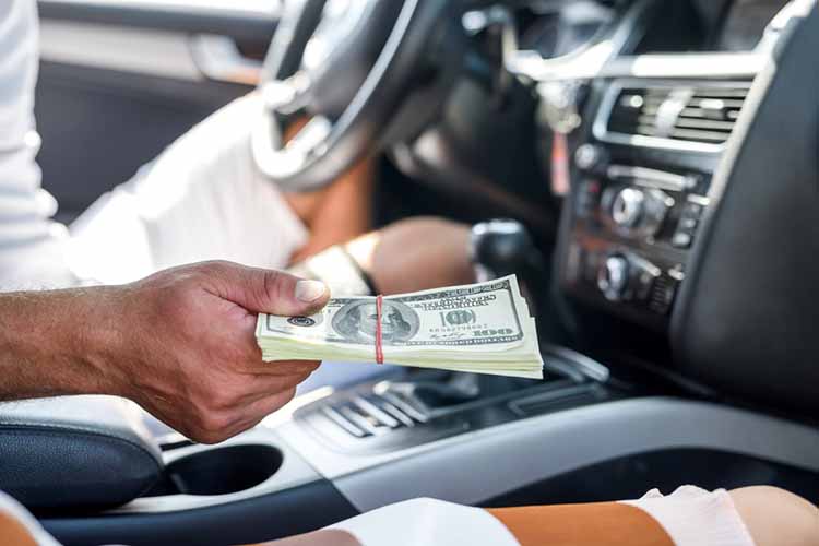 man holding car title loan cash