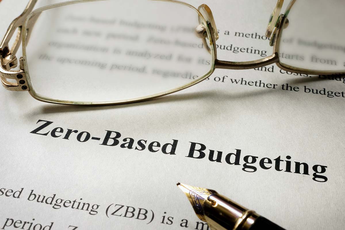 Image shows studying about zero-based budgeting with eye glasses and pen.