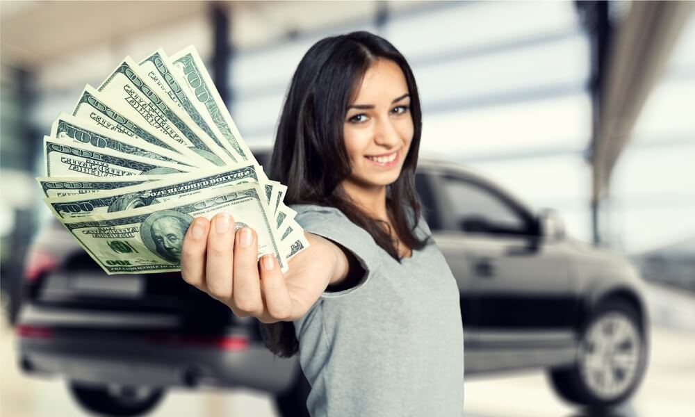 woman holding car title loan cash